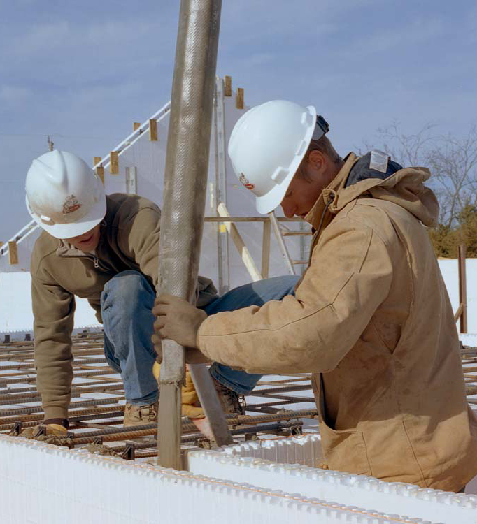 Contractors pouring concrete into installed ICF blocks, demonstrating the straightforward and efficient insulated concrete forms installation process.